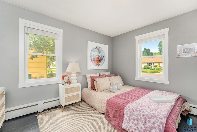 2109 W 37th St, Sioux Falls, SD 57105 - bedroom featuring a baseboard heating unit, multiple windows, and wood finished floors