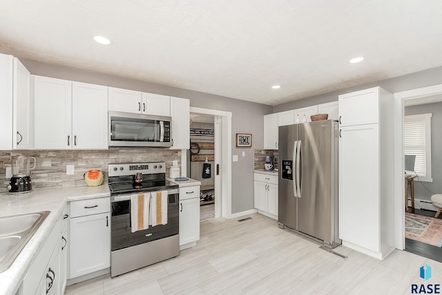 2109 W 37th St, Sioux Falls, SD 57105 - kitchen with appliances with stainless steel finishes, backsplash, white cabinets, light countertops, and recessed lighting