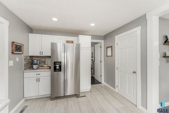 2109 W 37th St, Sioux Falls, SD 57105 - kitchen featuring stainless steel fridge, white cabinetry, recessed lighting, light countertops, and backsplash