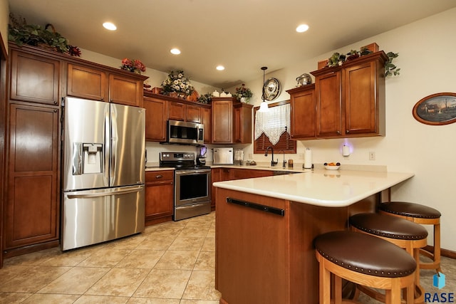 212 S Augusta Ave, Brandon, SD 57005 - kitchen featuring stainless steel appliances, a peninsula, a kitchen bar, recessed lighting, and light countertops