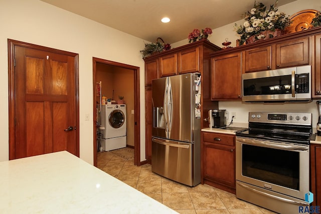 212 S Augusta Ave, Brandon, SD 57005 - kitchen with appliances with stainless steel finishes, light countertops, light tile patterned floors, washer and clothes dryer, and recessed lighting