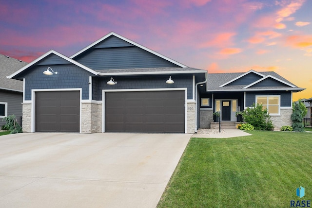 920 S Torrey Pine Ln, Sioux Falls, SD 57110 - view of front of house with stone siding, a garage, a front yard, driveway, and roof with shingles