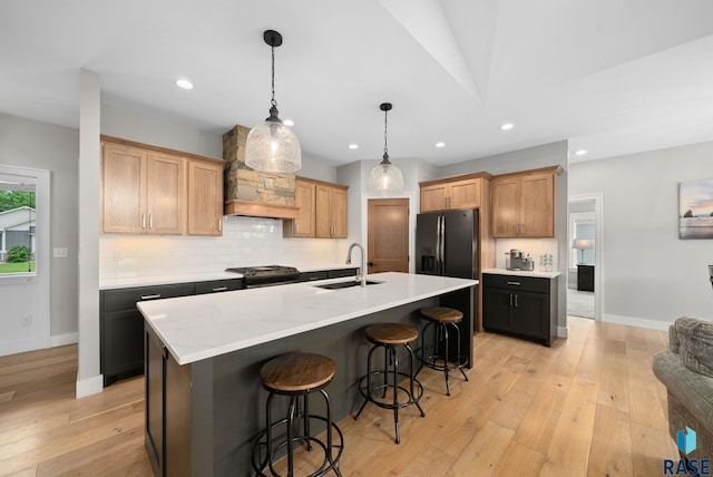 920 S Torrey Pine Ln, Sioux Falls, SD 57110 - kitchen with light wood-type flooring, tasteful backsplash, a breakfast bar, recessed lighting, and an island with sink
