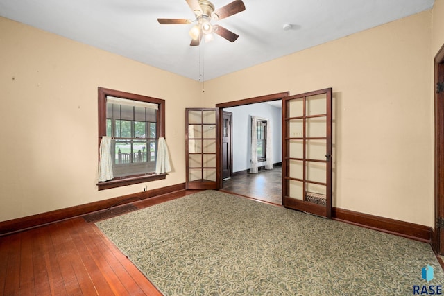 300 S Ash St, Lennox, SD 57039 - spare room featuring a ceiling fan, french doors, hardwood / wood-style flooring, and a smoke detector