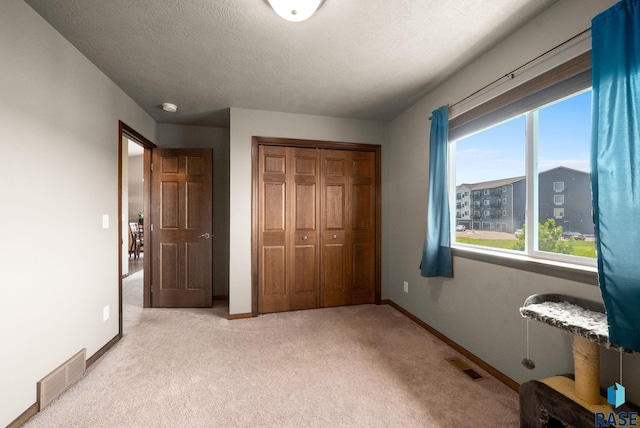 301 N Jenny Ave, Tea, SD 57064 - unfurnished bedroom with light carpet, a closet, and a textured ceiling