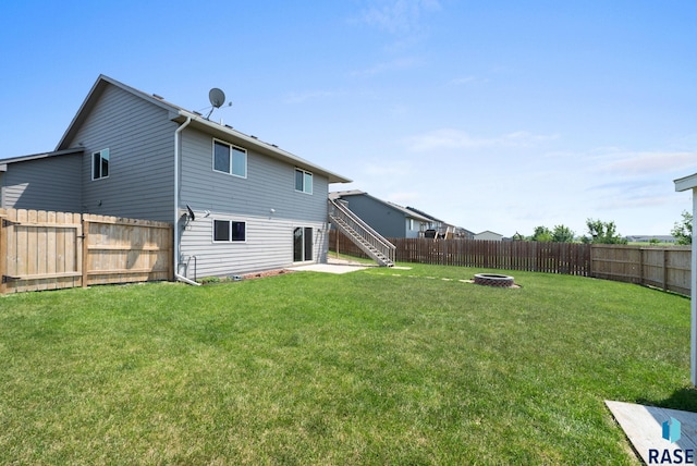 301 N Jenny Ave, Tea, SD 57064 - back of property with a fire pit, stairway, and a fenced backyard