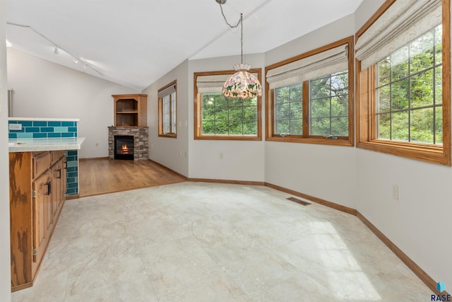 4220 S Minnesota Ave Unit 206, Sioux Falls, SD 57105 - unfurnished dining area featuring healthy amount of natural light, track lighting, a fireplace, and lofted ceiling