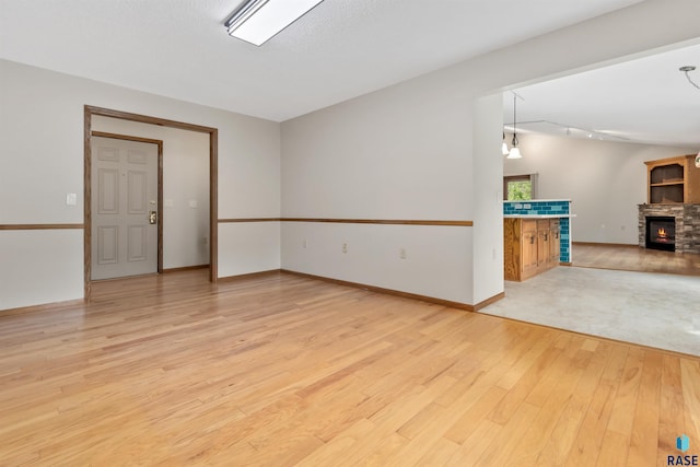 4220 S Minnesota Ave Unit 206, Sioux Falls, SD 57105 - unfurnished room featuring light wood-type flooring and a stone fireplace