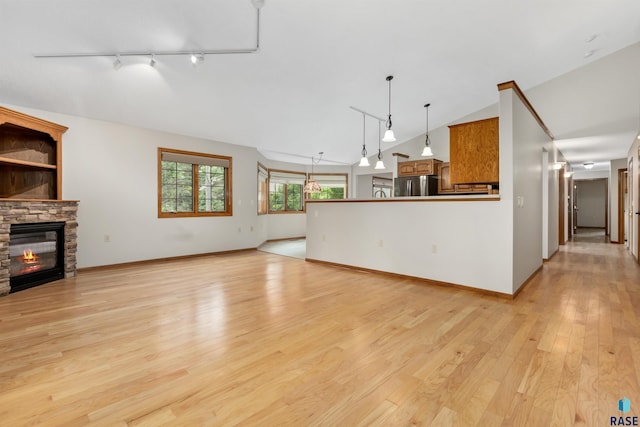 4220 S Minnesota Ave Unit 206, Sioux Falls, SD 57105 - unfurnished living room featuring track lighting, a fireplace, light wood-type flooring, and high vaulted ceiling