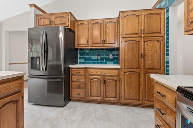 4220 S Minnesota Ave Unit 206, Sioux Falls, SD 57105 - kitchen featuring stainless steel refrigerator with ice dispenser, brown cabinetry, light countertops, tasteful backsplash, and vaulted ceiling