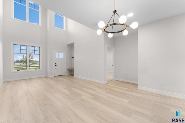 104 N Bryggen Pl, Sioux Falls, SD 57107 - empty room with a chandelier, light wood-style flooring, and a high ceiling