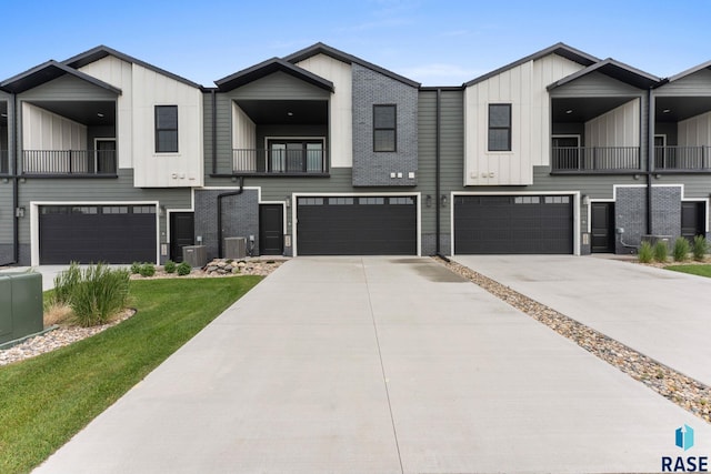 104 N Bryggen Pl, Sioux Falls, SD 57107 - townhome / multi-family property with board and batten siding, a balcony, a garage, and a front lawn