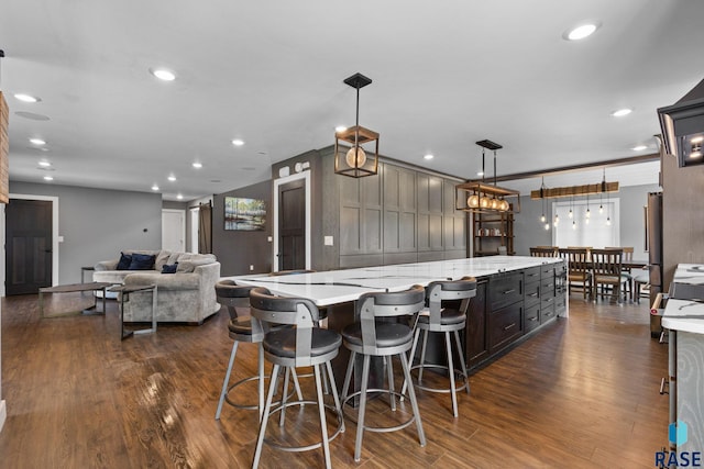 4513 S Southridge Dr, Sioux Falls, SD 57105 - kitchen with a large island, dark wood-type flooring, recessed lighting, decorative light fixtures, and light stone countertops