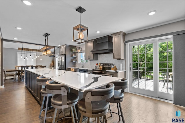 4513 S Southridge Dr, Sioux Falls, SD 57105 - kitchen with wall chimney range hood, stainless steel appliances, dark wood-style flooring, a center island, and backsplash