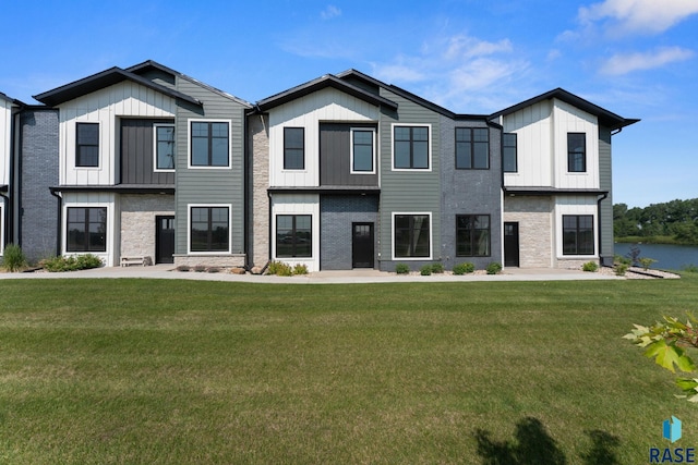 106 N Bryggen Pl, Sioux Falls, SD 57107 - view of front of house featuring board and batten siding, a front yard, and stone siding