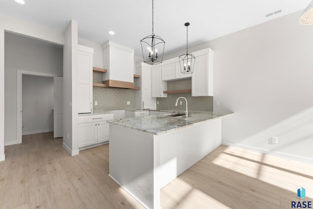 106 N Bryggen Pl, Sioux Falls, SD 57107 - kitchen with a peninsula, decorative backsplash, a chandelier, open shelves, and recessed lighting