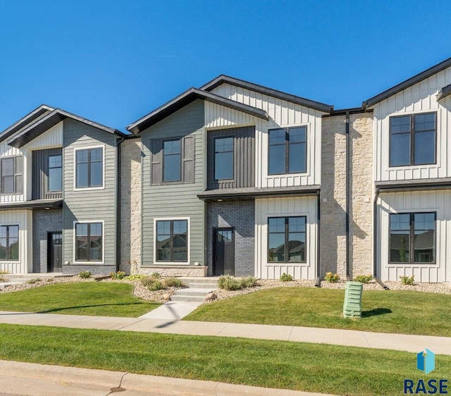 8611 W Shoreline Pl, Sioux Falls, SD 57107 - view of front of home featuring board and batten siding and a front lawn