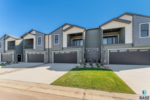 8611 W Shoreline Pl, Sioux Falls, SD 57107 - view of front facade featuring a garage, concrete driveway, board and batten siding, and a balcony