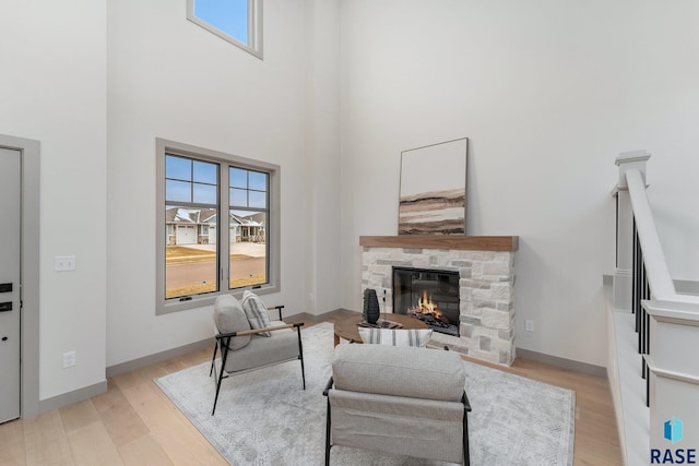 8611 W Shoreline Pl, Sioux Falls, SD 57107 - living room with light wood-style floors, a stone fireplace, and a high ceiling