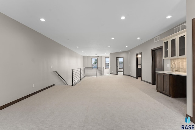 8619 W Shoreline Pl, Sioux Falls, SD 57107 - unfurnished room featuring recessed lighting, light colored carpet, and bar