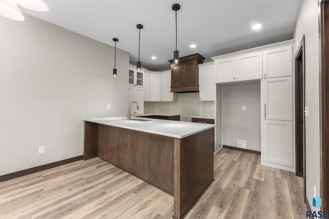 8619 W Shoreline Pl, Sioux Falls, SD 57107 - kitchen with a peninsula, backsplash, light wood finished floors, white cabinets, and light countertops