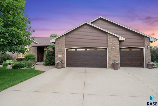 4400 E Aster Cir, Sioux Falls, SD 57103 - view of front of home featuring a garage, brick siding, concrete driveway, and a front lawn