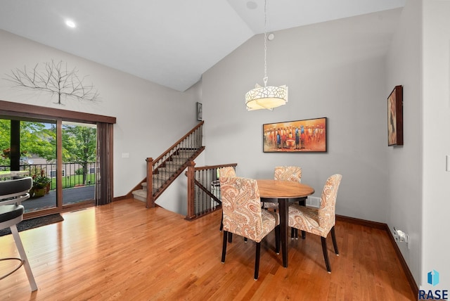 4400 E Aster Cir, Sioux Falls, SD 57103 - dining space featuring light wood-type flooring, high vaulted ceiling, and stairway