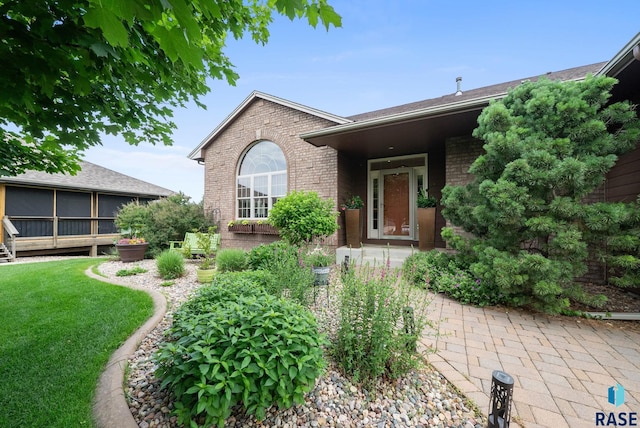 4400 E Aster Cir, Sioux Falls, SD 57103 - doorway to property with brick siding and a lawn