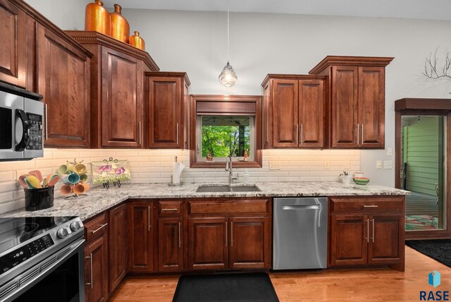 4400 E Aster Cir, Sioux Falls, SD 57103 - kitchen featuring stainless steel appliances, backsplash, light wood-type flooring, and light stone countertops