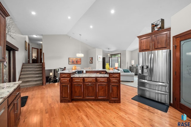 4400 E Aster Cir, Sioux Falls, SD 57103 - kitchen with stainless steel fridge with ice dispenser, lofted ceiling, light wood-style floors, a kitchen island, and light stone countertops