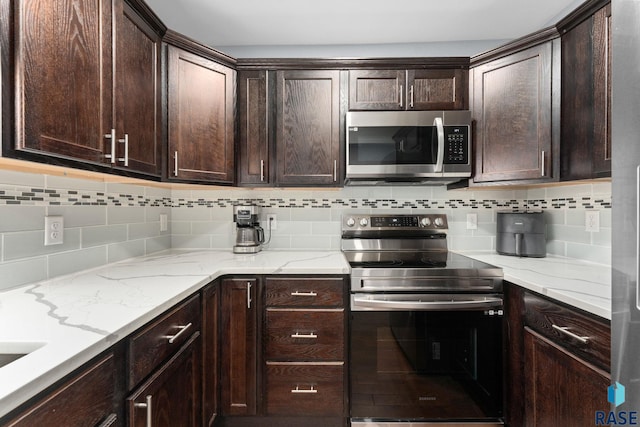 600 Sunnyside Ave, Valley Springs, SD 57068 - kitchen with stainless steel appliances, decorative backsplash, dark brown cabinetry, and light stone countertops