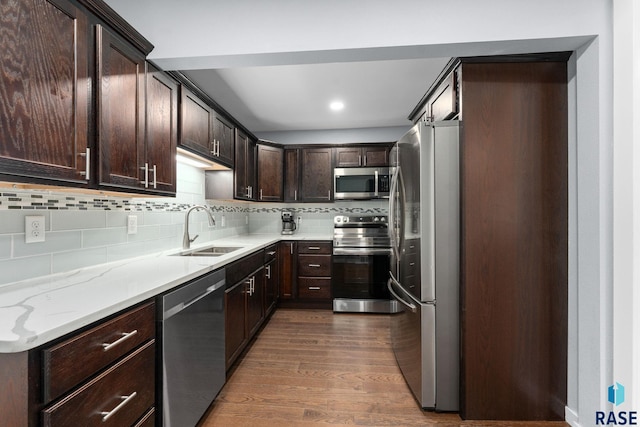 600 Sunnyside Ave, Valley Springs, SD 57068 - kitchen featuring appliances with stainless steel finishes, dark wood-style floors, dark brown cabinetry, backsplash, and light stone counters