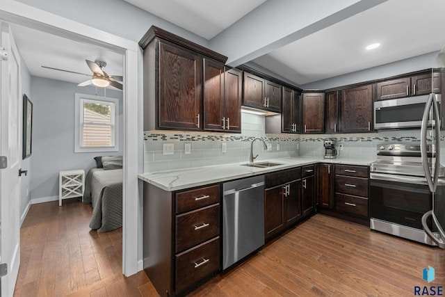 600 Sunnyside Ave, Valley Springs, SD 57068 - kitchen with stainless steel appliances, dark brown cabinets, decorative backsplash, a ceiling fan, and dark wood-style floors
