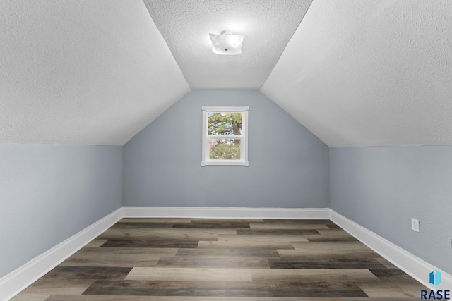 307 W Oak St, Beresford, SD 57004 - bonus room with a textured ceiling, vaulted ceiling, and dark wood-type flooring