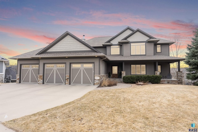 9005 E Torrey Pine Cir, Sioux Falls, SD 57110 - craftsman-style house with a garage, roof with shingles, concrete driveway, stone siding, and covered porch