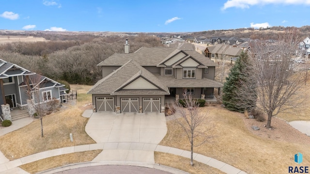 9005 E Torrey Pine Cir, Sioux Falls, SD 57110 - craftsman-style home featuring roof with shingles, concrete driveway, a porch, a chimney, and a residential view