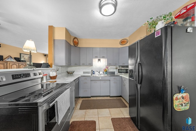 26045 485th Ave, Valley Springs, SD 57068 - kitchen featuring appliances with stainless steel finishes, gray cabinetry, light countertops, and light tile patterned floors