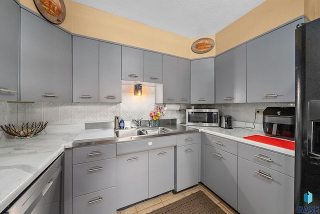 26045 485th Ave, Valley Springs, SD 57068 - kitchen with gray cabinetry, appliances with stainless steel finishes, tasteful backsplash, and light tile patterned flooring