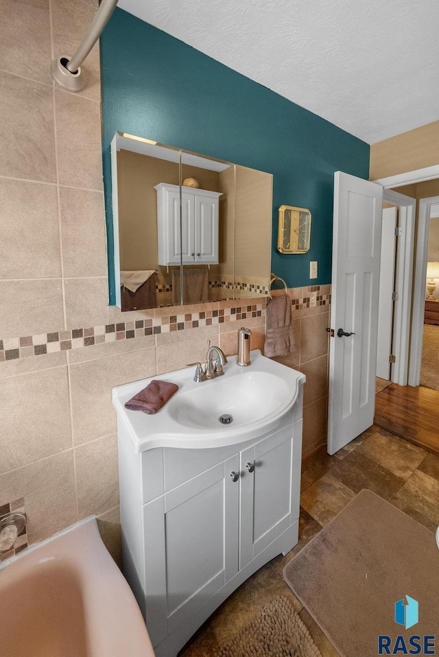 26045 485th Ave, Valley Springs, SD 57068 - bathroom with tile walls, vanity, and a bath