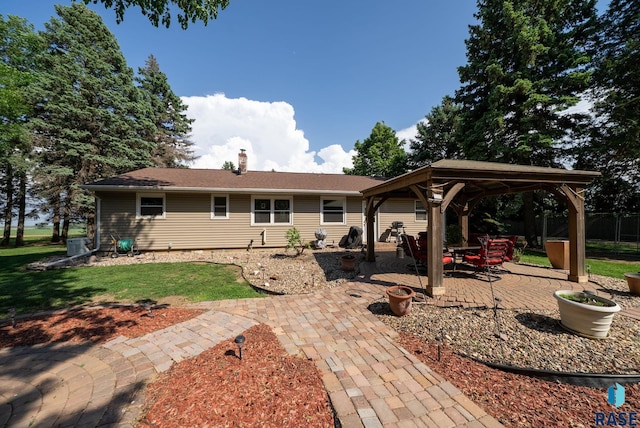 26045 485th Ave, Valley Springs, SD 57068 - rear view of property featuring a gazebo, a chimney, a patio area, and a lawn
