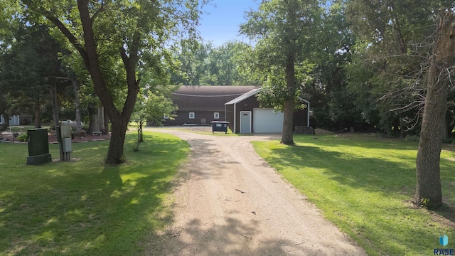 26045 485th Ave, Valley Springs, SD 57068 - view of front of house featuring an attached garage, dirt driveway, and a front lawn