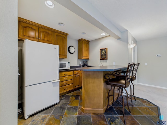 18 S Elkjer Cir, Sioux Falls, SD 57103 - kitchen featuring white appliances, brown cabinetry, a breakfast bar area, recessed lighting, and a peninsula