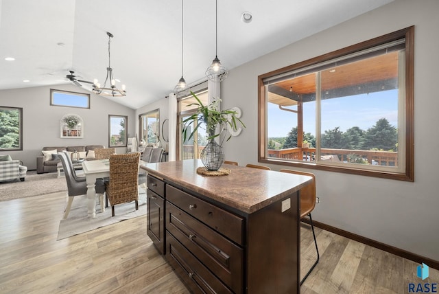 212 N Fairway Dr, Brandon, SD 57005 - kitchen featuring a chandelier, vaulted ceiling, light wood-style flooring, dark brown cabinetry, and a center island