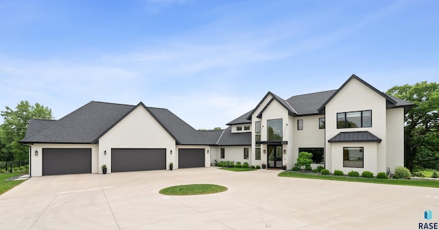 1617 S Scarlet Oak Pl, Sioux Falls, SD 57110 - modern inspired farmhouse featuring stucco siding, an attached garage, curved driveway, french doors, and a standing seam roof