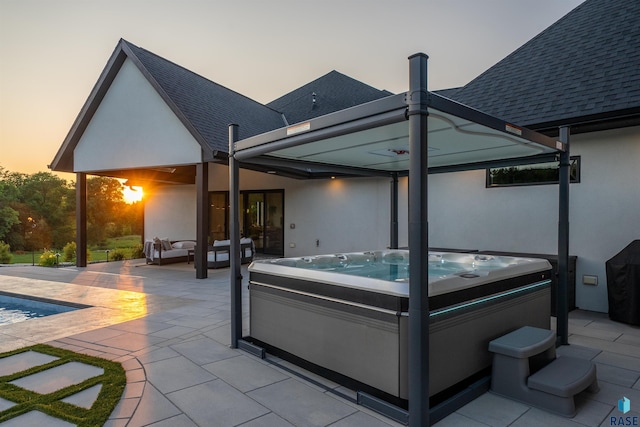 1617 S Scarlet Oak Pl, Sioux Falls, SD 57110 - back of house at dusk featuring a hot tub, a patio, a shingled roof, stucco siding, and outdoor lounge area