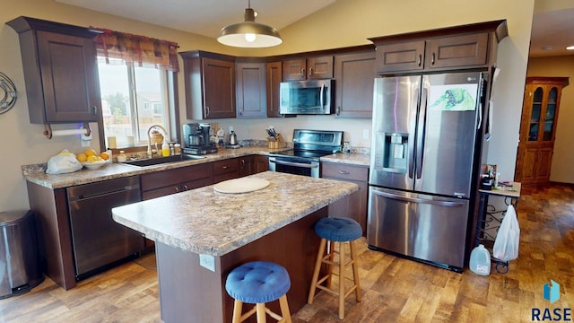 210 Lindsay Dr, Aurora, SD 57002 - kitchen with stainless steel appliances, light wood finished floors, a center island, a breakfast bar area, and vaulted ceiling