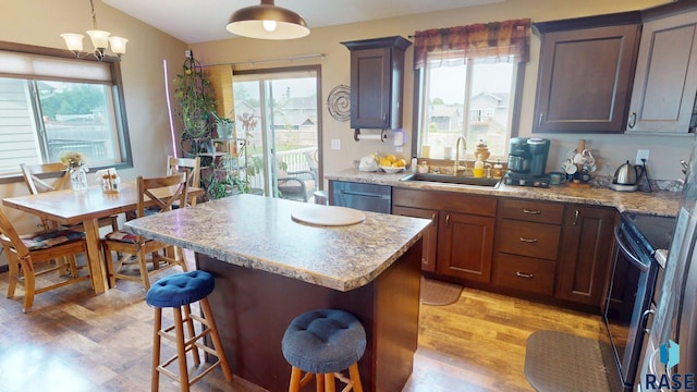 210 Lindsay Dr, Aurora, SD 57002 - kitchen featuring range with electric cooktop, light wood-type flooring, stainless steel dishwasher, a kitchen island, and plenty of natural light