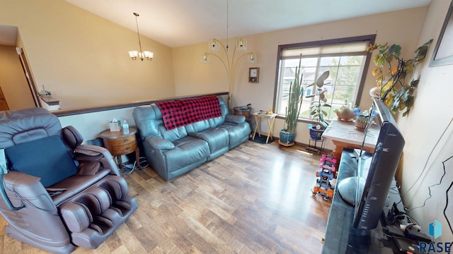 210 Lindsay Dr, Aurora, SD 57002 - living room featuring wood finished floors, a chandelier, and vaulted ceiling