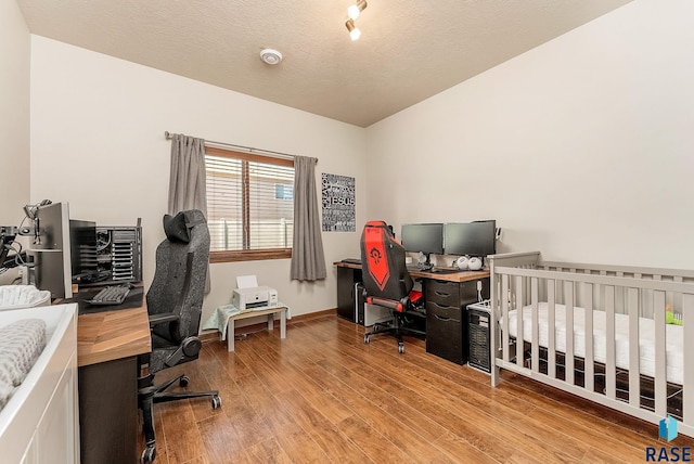 4005 S Grand Slam Ave, Sioux Falls, SD 57110 - bedroom with a desk, wood finished floors, and a textured ceiling