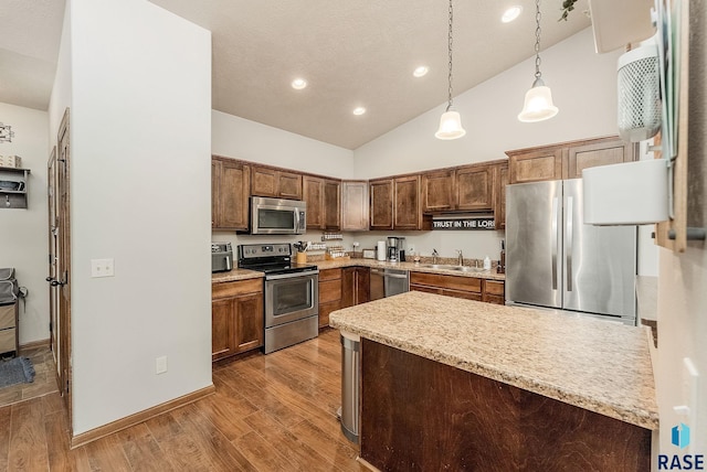 4005 S Grand Slam Ave, Sioux Falls, SD 57110 - kitchen with appliances with stainless steel finishes, wood finished floors, decorative light fixtures, recessed lighting, and high vaulted ceiling